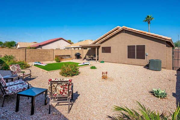 A backyard with a patio area, a barbecue grill, and a small pool.