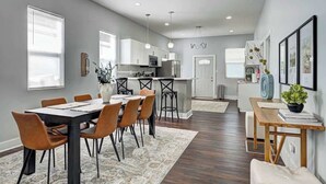 Une cuisine moderne avec des meubles blancs, un îlot central et des luminaires suspendus.