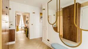 Una habitación amplia con un armario de madera, un banco y un espejo grande.