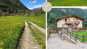 Propiedad rural con un sendero de tierra, un muro de piedra y una valla de madera.