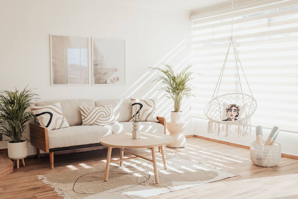 A modern living room with a sofa, coffee table, and hanging chair.