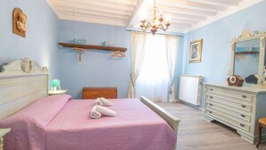 Ein Schlafzimmer mit Bett, Schminktisch und einer Chandelüstere.