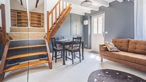 Ein modernes Wohnzimmer mit Treppe, Essbereich und einer Couch.