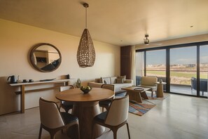 Een moderne woonkamer met een eethoek, grote ramen en uitzicht op de omgeving.