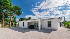 A single-story building with a covered entrance, a gravel driveway, and a clear sky.