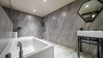 Un baño moderno con una bañera grande, un lavabo y una ducha.