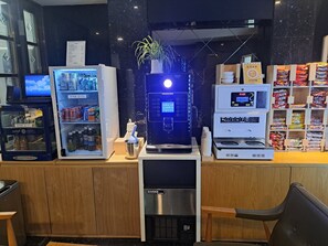 A self-service beverage station with a coffee machine, a refrigerator stocked with drinks, and a snack vending machine. - Bulgwang 3S Hotel (Seoul)