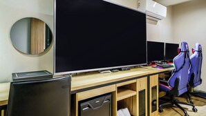 Un espacio de oficina moderno con un monitor de pantalla plana grande, múltiples monitores y sillas ergonómicas.