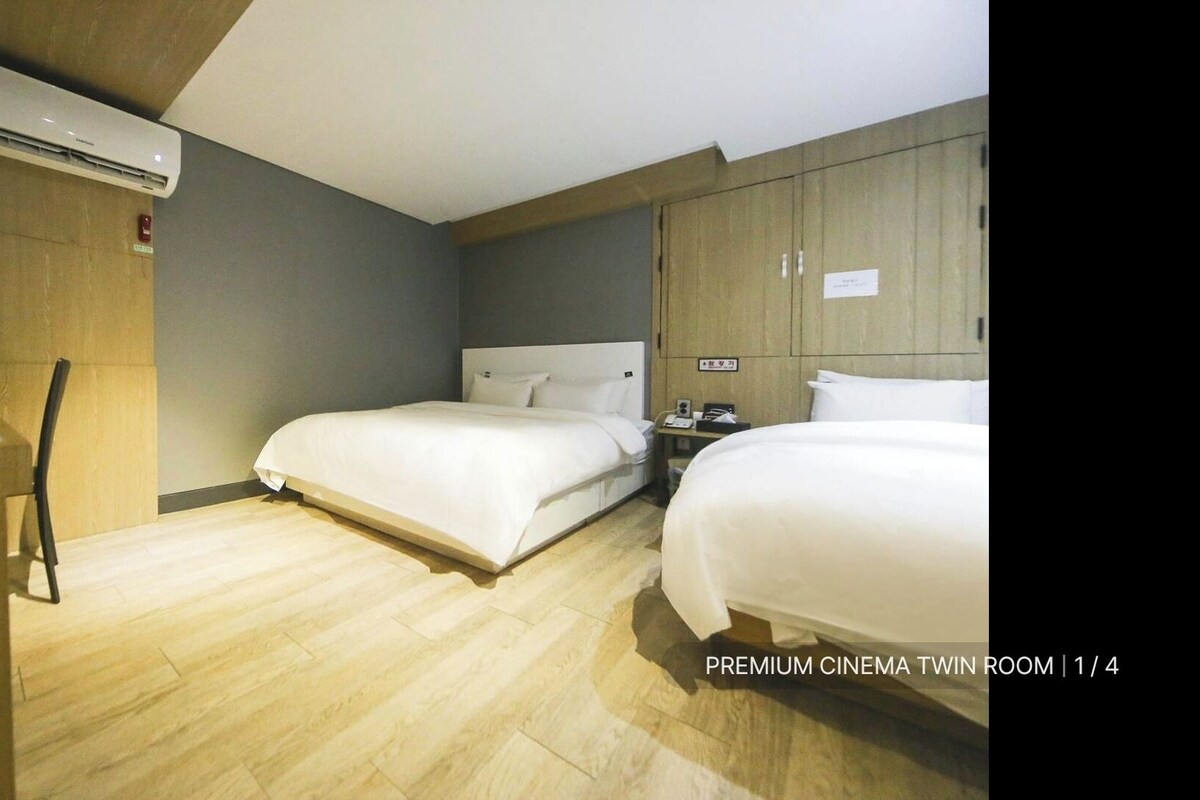 A room with two beds, a desk, and a wardrobe.