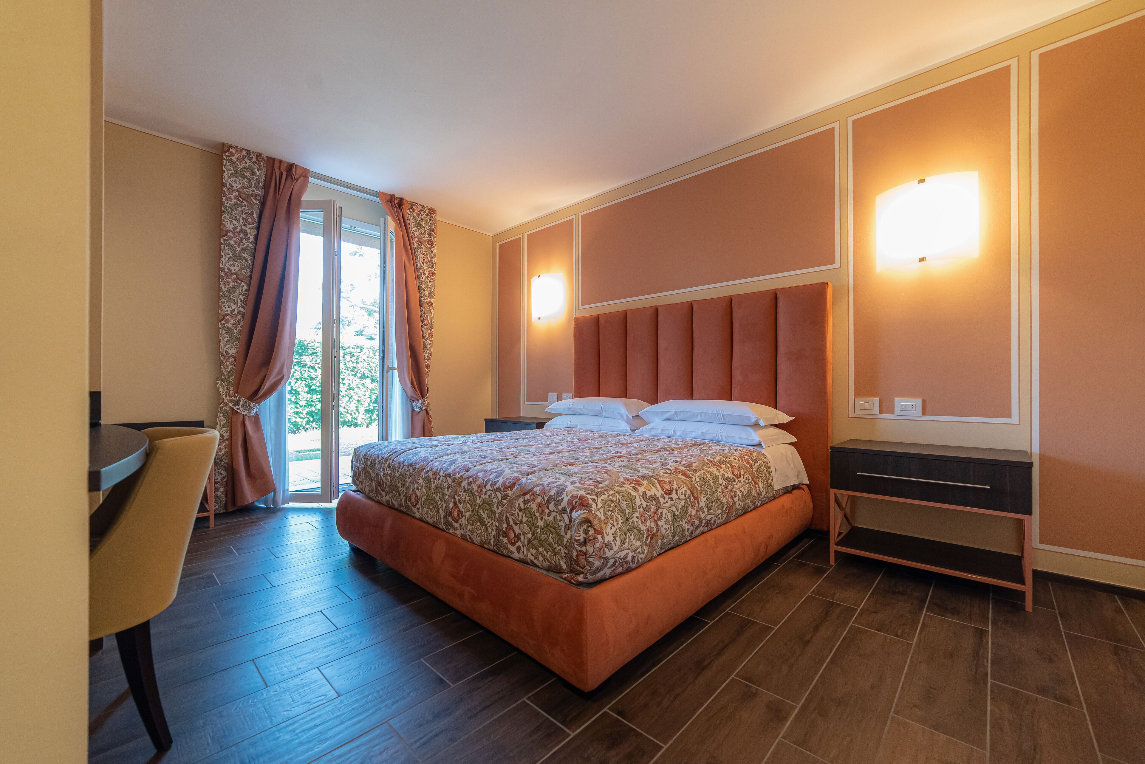 A bedroom with a bed, a desk, and a chair.