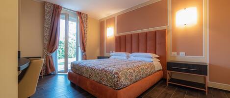 A bedroom with a bed, a desk, and a chair.