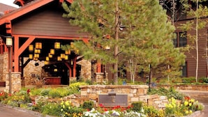 Eine Lodge mit Steinaußenwand, Holzbalken und einem Schild mit der Aufschrift "The Ritz Carlton Club".
