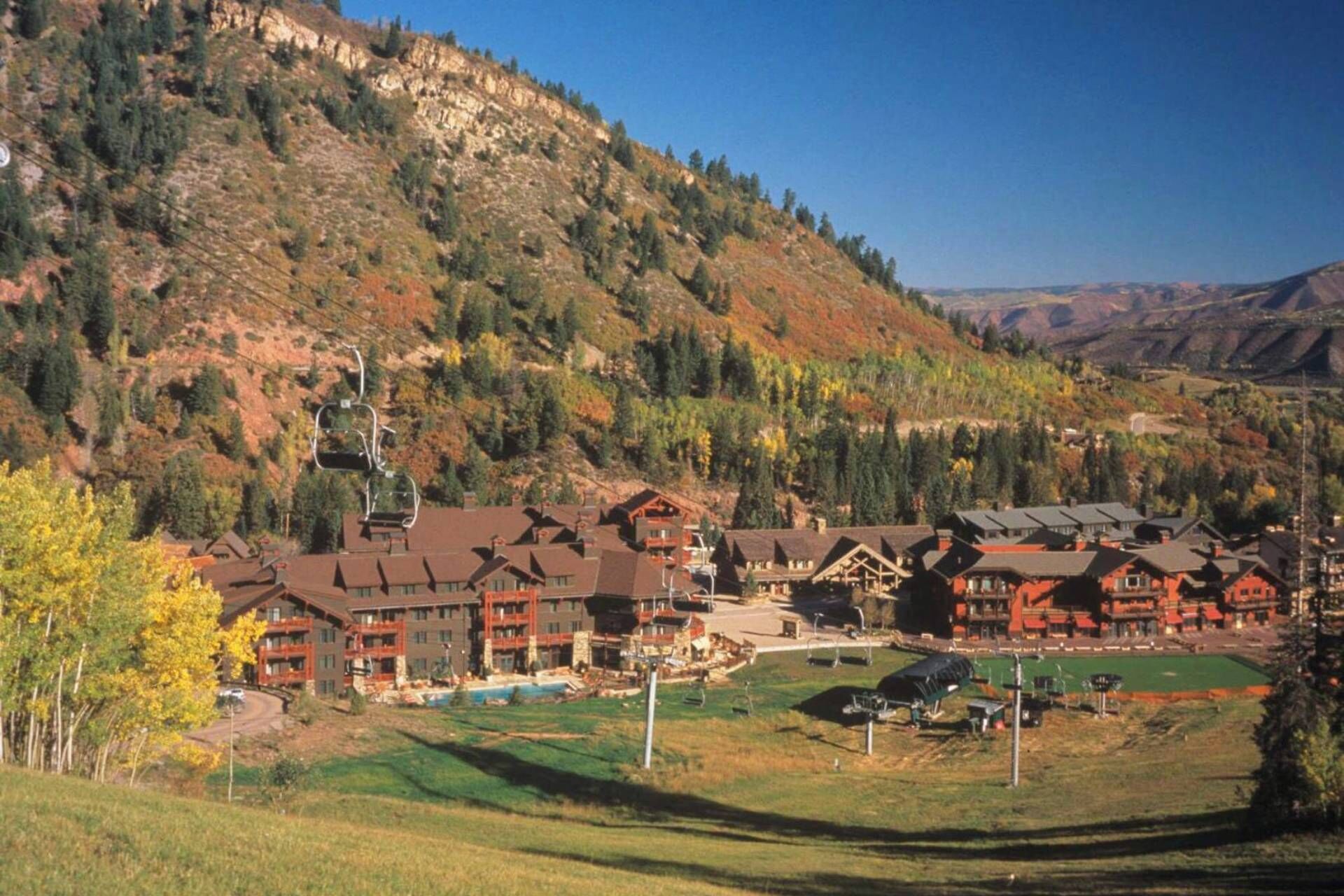 A lodge with multiple buildings, a ski lift, and a golf course.