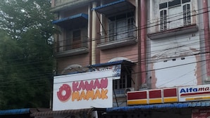 A building with a sign for 'OIKAWAN OIMAMAK' and a '15Ribu Per Box' price tag.