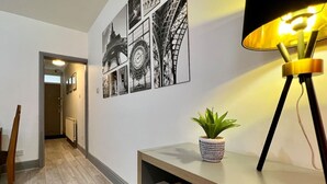 A hallway with a bookshelf, a potted plant, and a lamp. - St Michael`s House Contractors, Families, Groups (Nottingham)