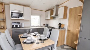 Una cucina moderna con zona pranzo, completa di forno a microonde, piano cottura e pensili.