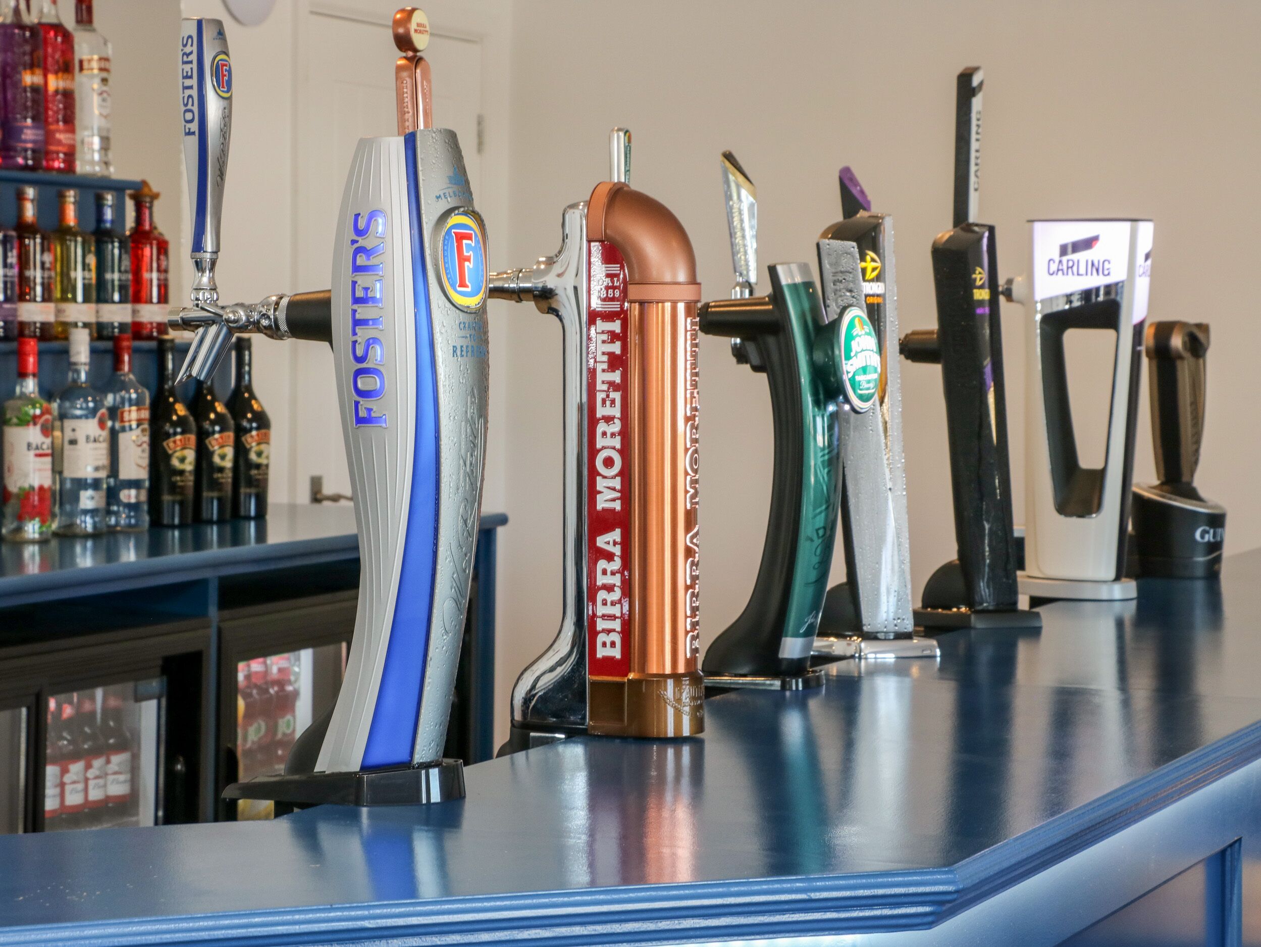 Un bar doté de plusieurs robinets, proposant notamment les bières « Foster’s » et « Birra Moretti ».