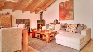 Una sala de estar acogedora con chimenea, un sofá, una mesa de centro y un televisor.