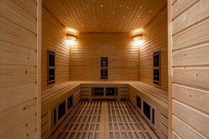 Una sauna con paredes, bancos y dos calentadores de pared de madera.