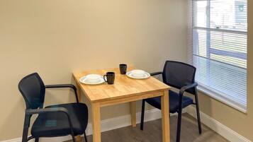 A small dining area with a wooden table and two chairs.