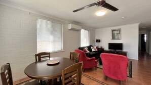 Un espace repas comprenant une table ronde, des chaises et un ventilateur de plafond.