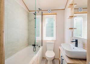A bathroom with a bathtub, toilet, and sink.