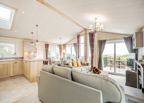 A spacious living area with a sofa, dining table, and kitchen area.