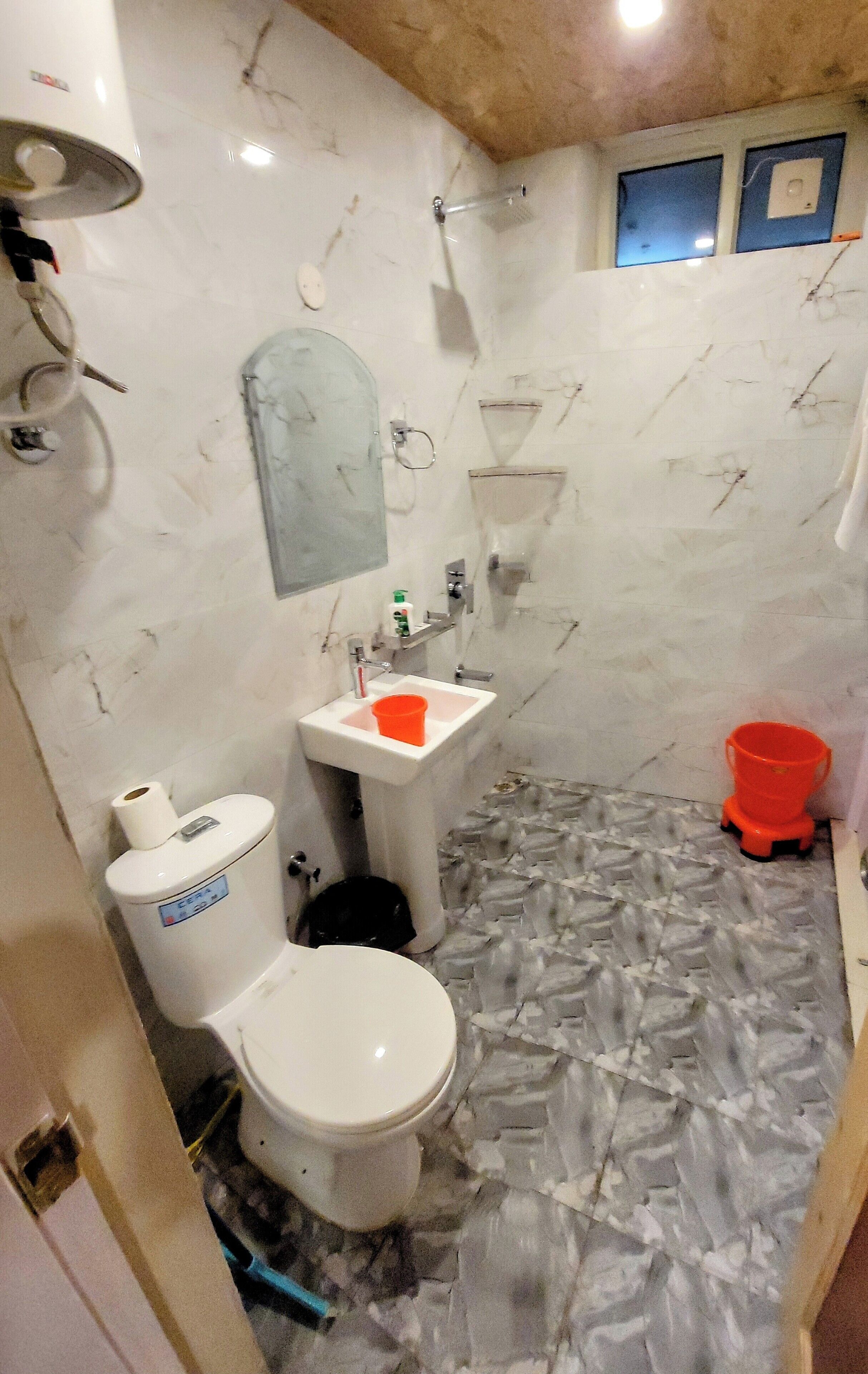 A bathroom with a toilet, sink, and shower.