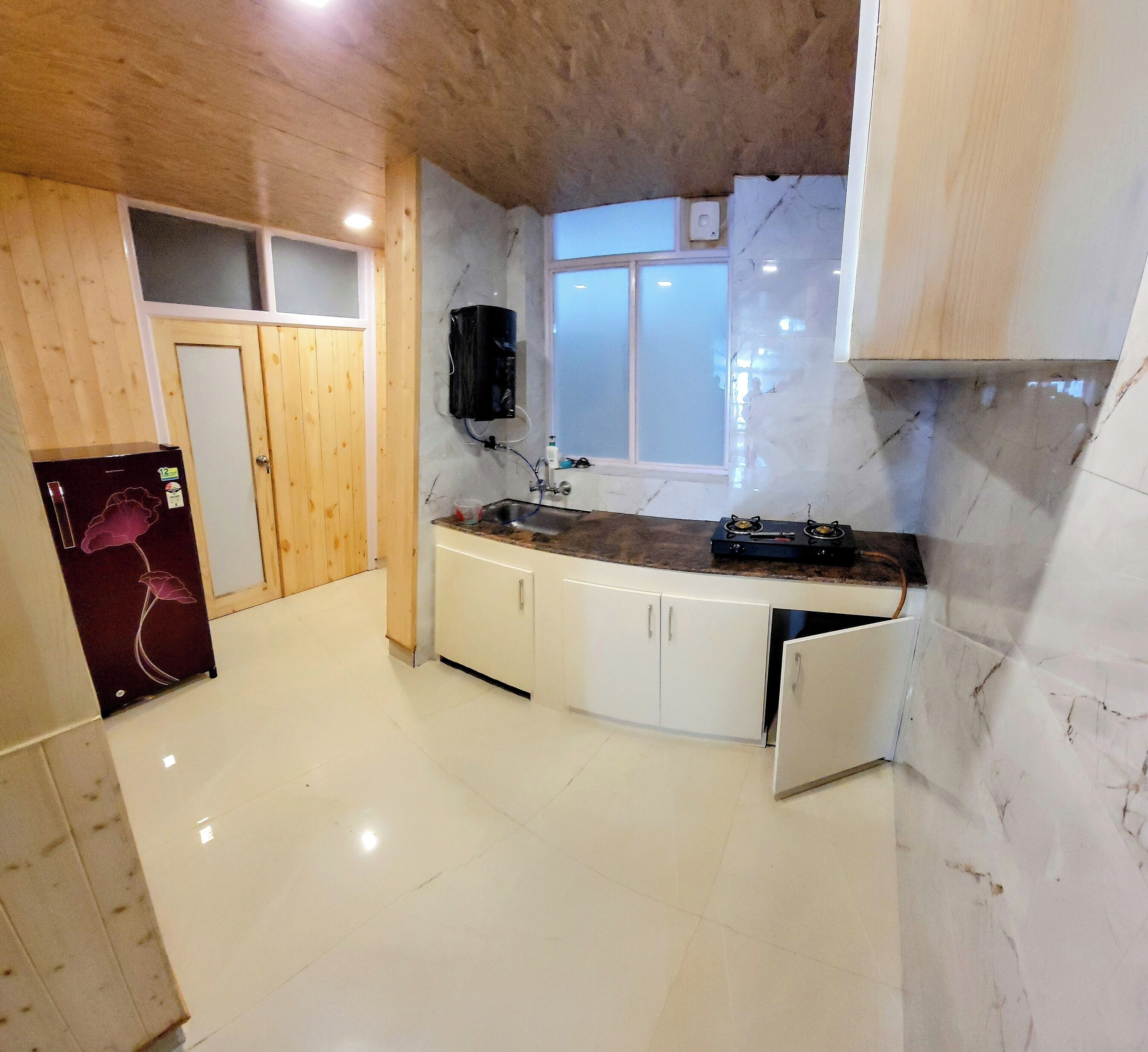 A kitchen with a marble countertop, wooden cabinets, and a built-in stove.