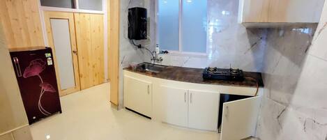 A kitchen with a marble countertop, wooden cabinets, and a built-in stove.