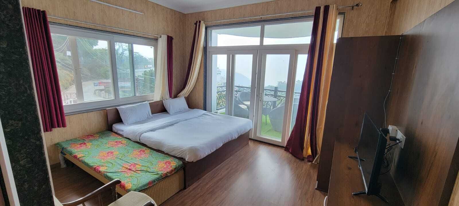 A bedroom with a bed, a small table, and a TV.