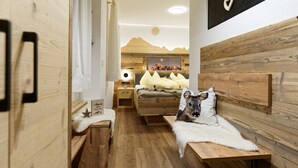 Una camera accogliente con pareti e mobili in legno, un letto con cuscini, un comodino e un quadro appeso al muro.
