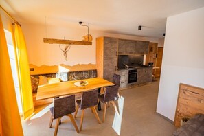 Una cocina moderna con una mesa de comedor de madera, sillas y un horno empotrado.