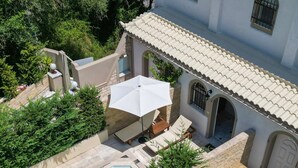 A rooftop pool area with two swimming pools, lounge chairs, and umbrellas. - Doliva Erietta Apartment with Private Pool, Mountain View, Wi-Fi & Air Conditioning (Corfu)