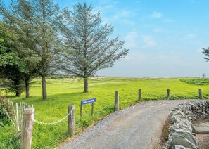 A rural golf course with a gravel path leading to a sign marked 'GOLF COURSE.' - 2 bedroom accommodation in Kirkcudbright (Kirkcudbright)