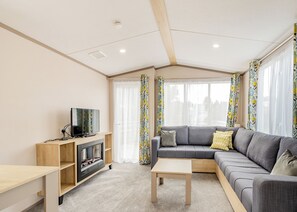 Uma sala de estar moderna com sofá, TV e lareira.