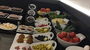Ein Buffet mit verschiedenen Speisen, darunter Obst, Gemüse und Desserts.