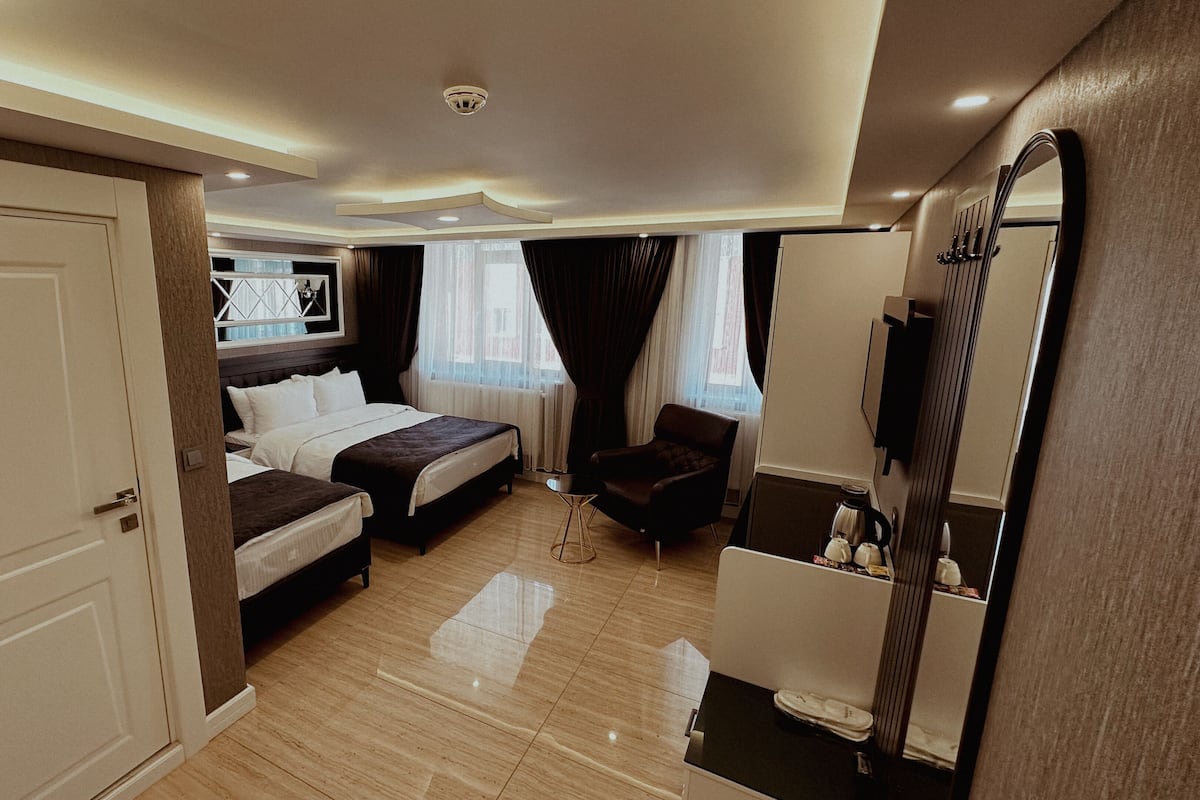 A hotel room with a bed, a chair, a desk, and a mirror.