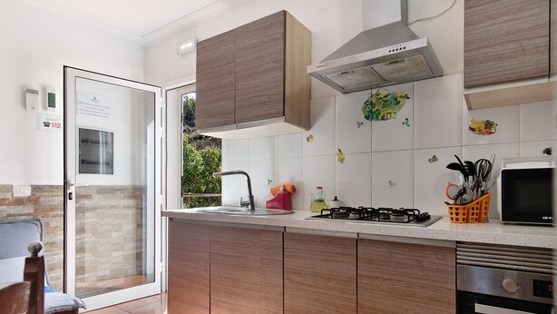 A modern kitchen with wooden cabinets, a gas stove, a microwave, and a dishwasher.