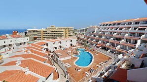 Et resort med swimmingpool, flere altaner og havudsigt.