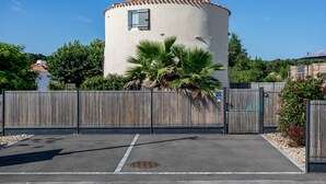 A cylindrical building with a tiled roof, a small window, and a metal fence in front. - La Tourette – Charming, Unique Cottage with Private Terrace, Garden, and Wi-Fi (Jard Sur Mer)