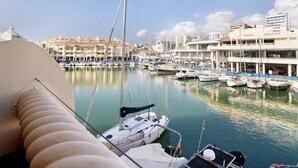 A marina with multiple boats docked, a large building with balconies, and a clear sky. - Studio Apartment "Puerto Marina Luxury" with Sea View & Wi-Fi (Benalmádena)
