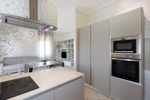Une cuisine moderne dotée d’appareils électroménagers intégrés, un coin repas et un espace de vie.