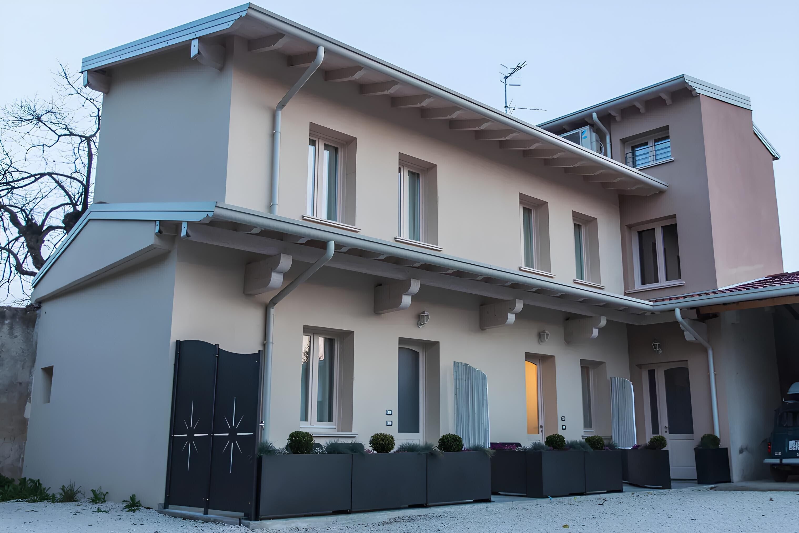 Un bâtiment à deux étages, doté d’un toit plat, de nombreuses fenêtres et d’une entrée fermée par un portail.