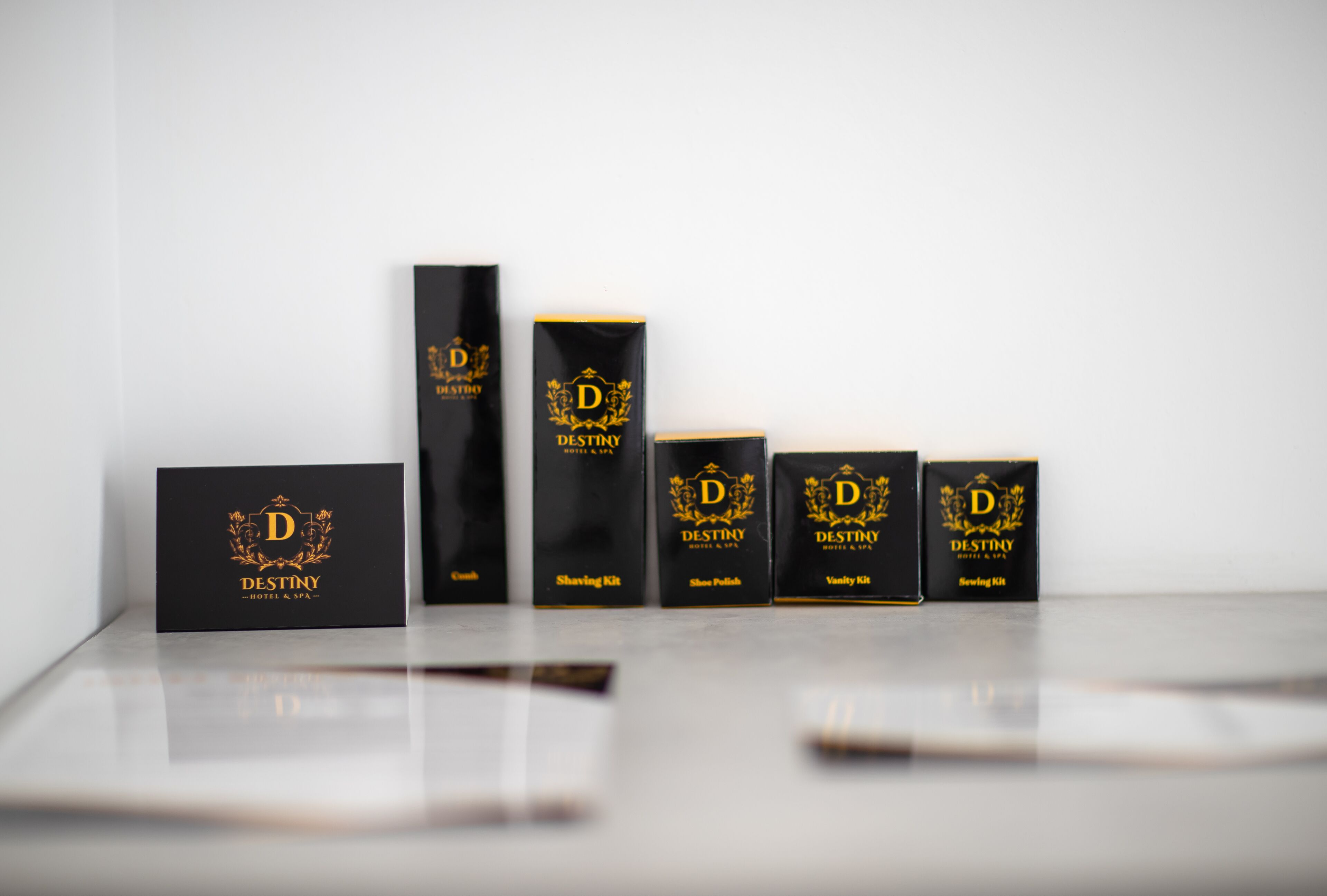 A row of black boxes with gold lettering and designs, labeled with "DESTINY HOTEL & SPA."