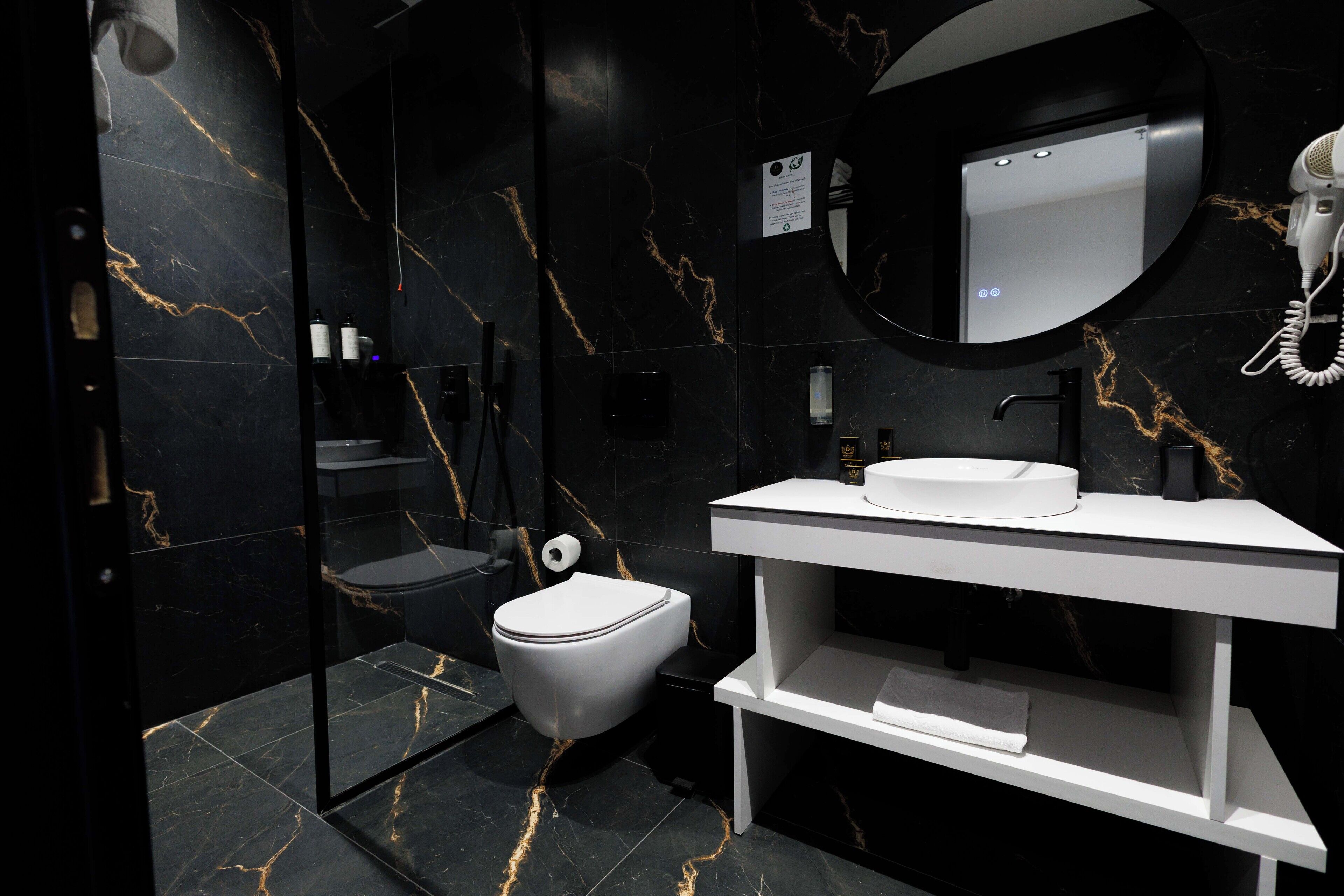 Een moderne badkamer met een wit wastafel, toilet en spiegel.