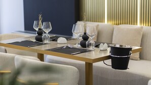 A dining table set with wine glasses, a vase, and a bucket. - Destiny Hotel (Kashar)