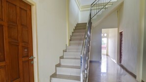 A staircase with a metal handrail leading to an upper floor. - OYO Life 92637 Kost Arya Exclusive (Jambi)