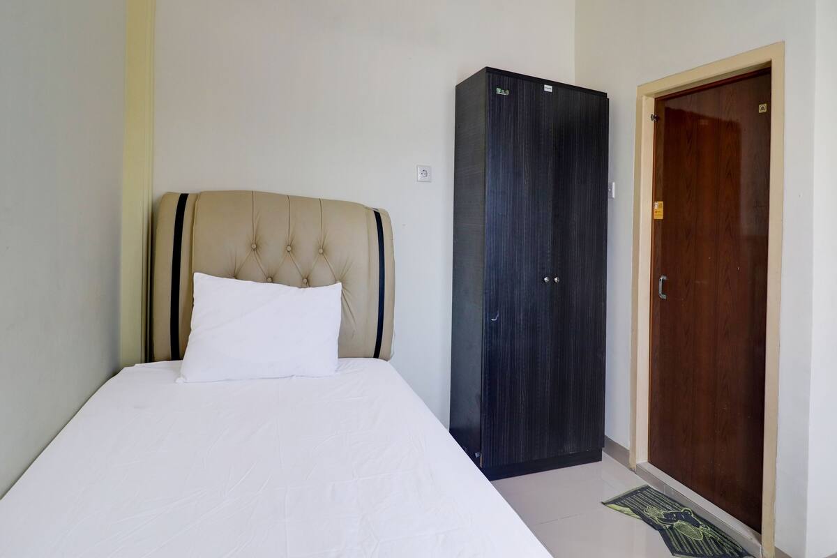 A bedroom with a bed, a wardrobe, and a door.