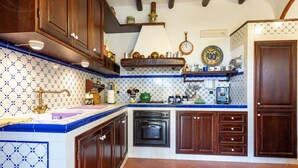 A kitchen with wooden cabinets, a built-in oven, and a tiled backsplash. - Holiday Home 'Villa Sofia' with Private Garden and Balcony (Salemi)